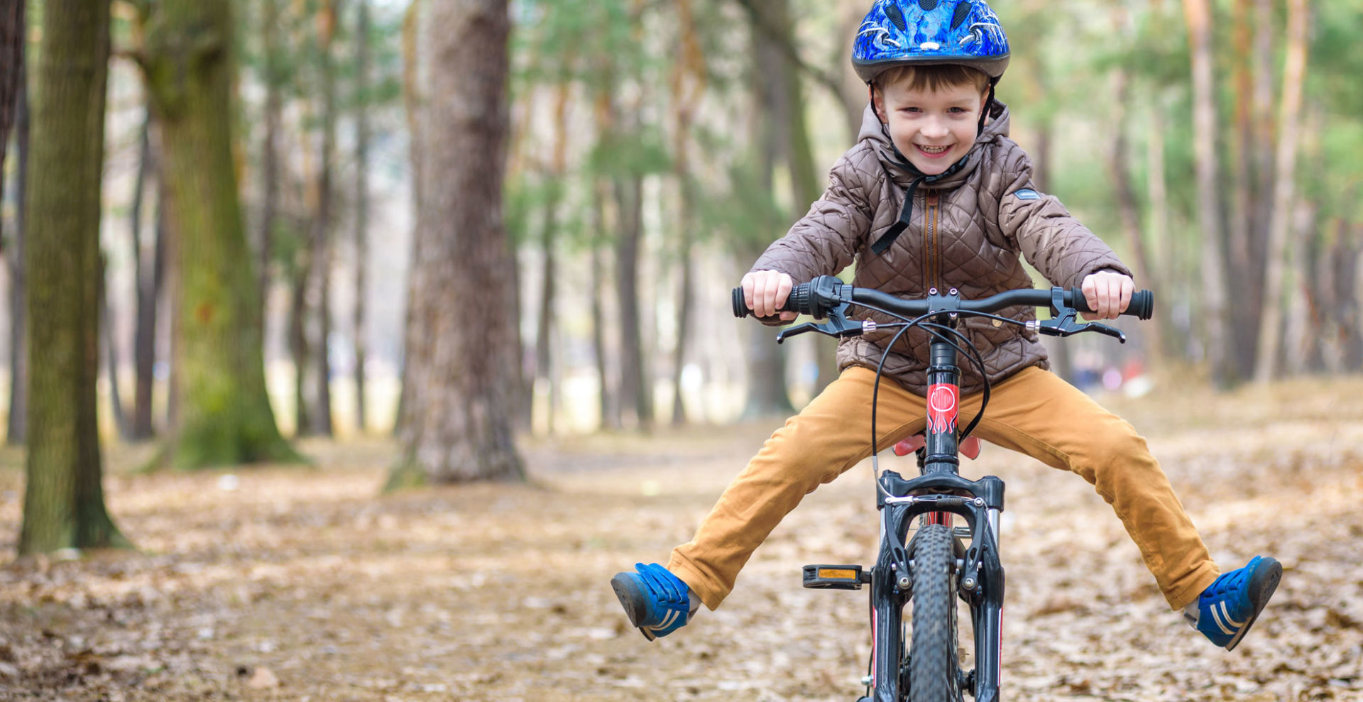 pieni poika ajaa polkupyörällä metsässä