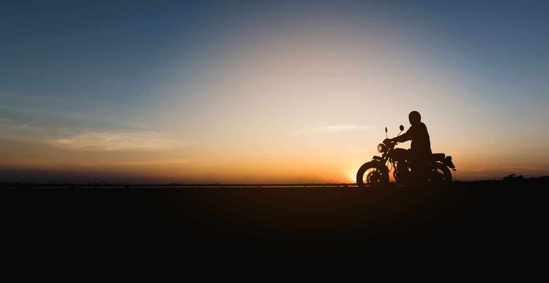 moottoripyörän siluetti illan hämärässä auringonlaskussa