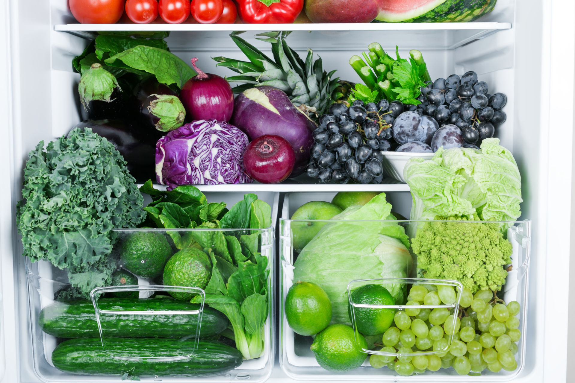 Jääkaappi jossa vihreitä kasviksia ja elintarvikkeita